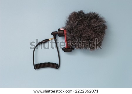 a close up of microphone for mobile phone and camera isolated on blue background. sound technology photo concept.