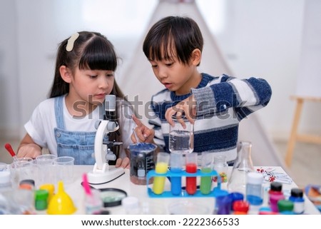 At school children play education study mix paint with water in laboratory glass as scientist