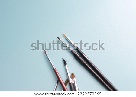 a close up of a painting brush isolated on a blue background. concept photo art.