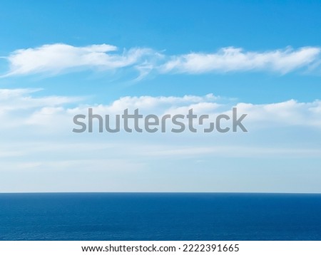 Blue sky clouds over calm sea water. Royalty-Free Stock Photo #2222391665