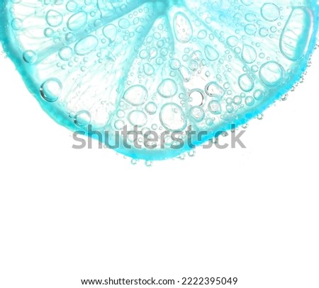 Juicy lime slices with bubbles under water isolated on white background. Light blue lemon slices pattern textured background.