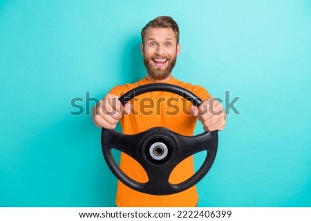 Portrait of crazy overjoyed man arms hold wheel steering toothy smile isolated on teal color background Royalty-Free Stock Photo #2222406399