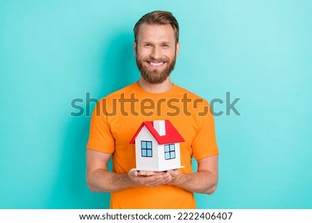 Photo of nice beard guy hold house wear orange t-shirt isolated on teal color backgroiund