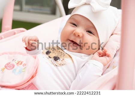 Close up Newborn baby girl sleeping in white stroller on a walk in summer park. New born child napping outdoors on hot sunny day. Infant in a city buggy. Kids sleep in pram. Royalty-Free Stock Photo #2222412231