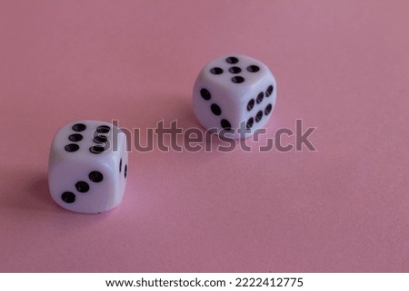 two white plastic dice on a pink background with free space to write