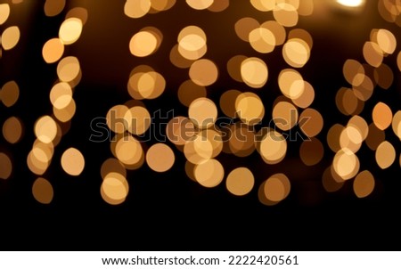 Golden defocused bokeh lights on top of the image on an isolated black background. Abstract magic background with bokeh effect, golden glitter for Christmas. Overlay for your design.High quality photo
