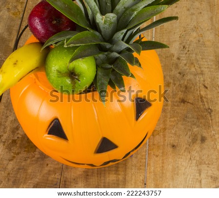 Halloween plastic pumpkin full of fruits