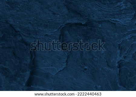 intense dark blue abstract background for advertising wallpaper.  Sea rock texture seen from above. Surface full of layers, lines, holes, bumps and other traces of natural water and wind erosion. 