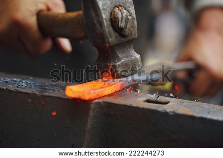 Detail shot of hammer forging hot iron at anvil Royalty-Free Stock Photo #222244273