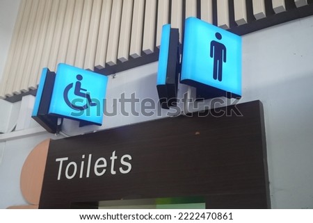 A sign indicating that there are public toilet facilities for men and the disabled.