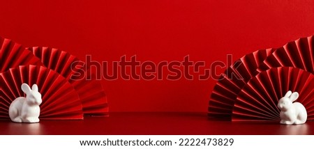 Happy Chinese New Year banner template. Red paper fans with rabbit decorations on red background. Traditional holiday lunar New Year. Happy New Year of the rabbit.