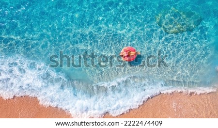 Concept banner tropical paradise travel relax. Aerial top view young woman swimming with donut pink inflatable swim ring in blue sea.
