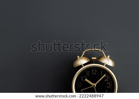 Golden alarm clock on dark background. Black Friday time. Selective focus, copy space