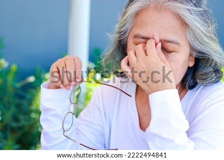 Asian elderly women have vision problems. Have eye pain. Eye disease in the elderly. cataracts, diabetic retinopathy Royalty-Free Stock Photo #2222494841