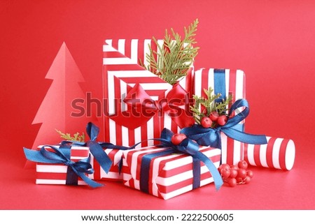 Wallpaper greeting card Merry Christmas holiday composition with blue white red striped gift box present pine fir tree decoration on red background. Xmas New Year winter design idea concept. 
