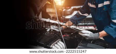 Car care maintenance and servicing, Close-up hand technician auto mechanic checking inspection list after repairing change spare part car engine problem and car insurance service. Royalty-Free Stock Photo #2222515247