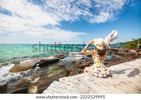 Young Asian lady tourist sitting on the wooden bridge in to the sea on her holiday, Trad province,Thailand.