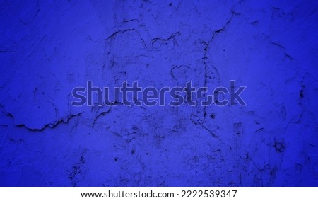 Old wall background in dark blue sided, Close up of cracked old cement texture. Peeling wall or road material