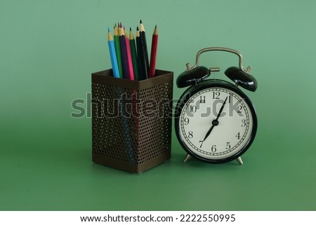 alarm clock with pencils in container