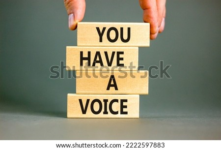 You have a voice symbol. Concept words You have a voice on wooden blocks. Beautiful grey table grey background. Businessman hand. Business, psychological you have a voice concept. Copy space.