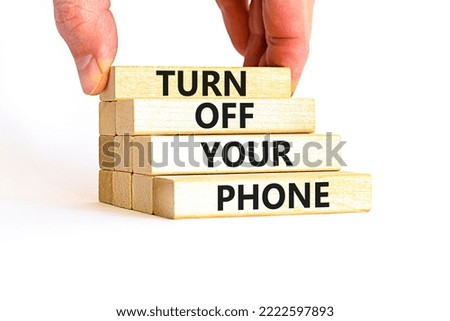 Turn off your phone symbol. Concept words Turn off your phone on wooden blocks. Beautiful white table white background. Businessman hand. Business psychological turn off your phone concept. Copy space