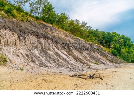 Landslide and rockfalls with stones of different sizes in summer in the beach.