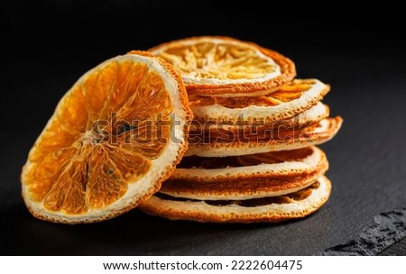 a stack of round slices of dried orange on a black background Royalty-Free Stock Photo #2222604475