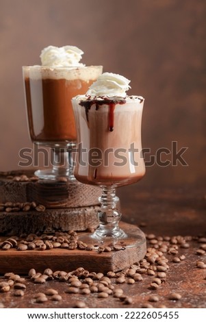 Coffee and chocolate drinks with whipped cream on a brown background.