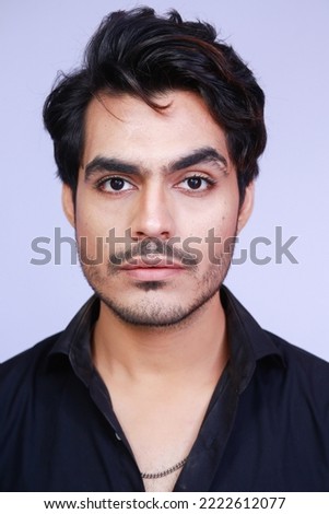 Portrait of a Pakistani young man with a stylish hair style, isolated on studio background