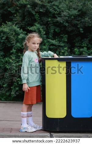 Separate garbage collection. Girl disposes of garbage for recycling. Selective focus, blurred background.