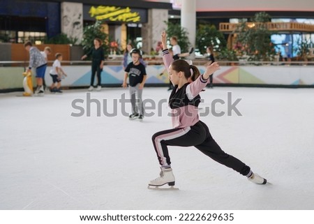 Girl trains figure skating. Selective focus, blurred background.