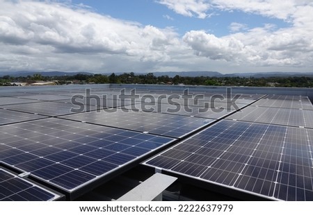 Solar Panels, on a Flat Roof Relecting Blue Sky and Light Clouds 