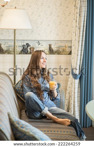 Beautiful girl drinking tea or coffee in the evening in her bedroom