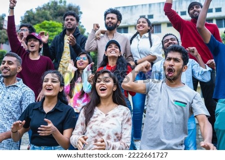 Group of audience at stadium shouting or screaming after winning the game during cricket sports match at stadium - concept of championship, tournament and entertainment
