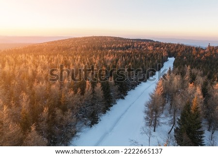 Sunset over Orlické hory (Eagle mountines) from Poland side in Jagodna. Forest and road covered in snow.