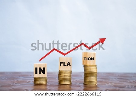 INFLATION word on a wooden cube on coins in idea for RBI consider interest rate hike, world economics, high inflation, Indian rupee inflation graph. Royalty-Free Stock Photo #2222666115
