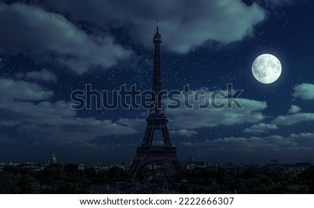 Paris at night during energy crisis, France. Full blackout of city due to expensive gas and electricity in Europe. View of Eiffel Tower and moon on dark sky. Concept of EU economy, sanctions, saving.
