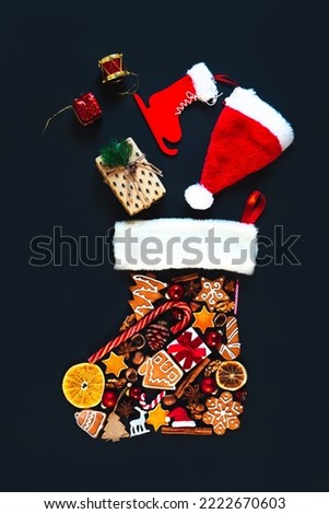 Christmas decor laid out in the shape of a boot. There are gifts flying. Christmas or New Year background. Flat lay, dark background.