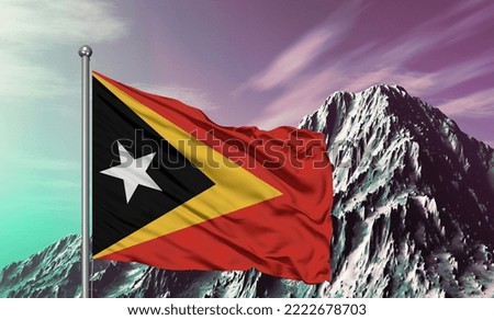 East Timor national flag cloth fabric waving on beautiful mountain background.