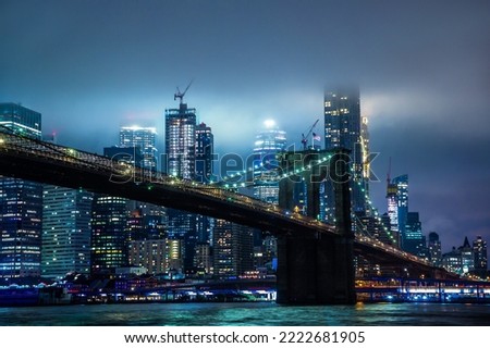 Brooklyn Bridge and panoramic night view of downtown Manhattan after sunset in New York City, USA