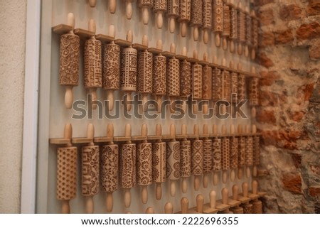 Wooden rolling pins for dough with a pattern on a shop window. Cooking concept