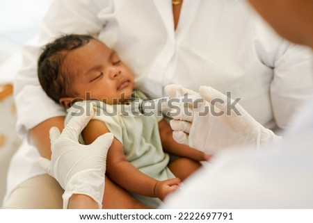 Close up of the hand and needle. Doctor holds syringe to vaccinate newborn baby one month old with injection. Concept clinic pediatrician health check Vaccine antivirus for infant.  Royalty-Free Stock Photo #2222697791