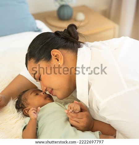 Portrait happy smiling of a beautiful Asian mother kissing nose-to-nose newborn baby son 1-month-old,  and looking at him with love. Adorable little infant sleep well in warm embrace of motherhood.