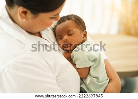 Newborn baby one-month-old sleeping well, worry-free on the warm mother's chest. Young mother cuddling adorable infant innocence after birth on arms. Concept of Parenthood, Motherhood, Adoption. Royalty-Free Stock Photo #2222697845