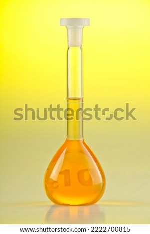 A Volumetric flask filled with orange liquid Royalty-Free Stock Photo #2222700815