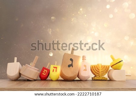 Image of jewish holiday Hanukkah with wooden dreidels collection (spinning top) over glitter background