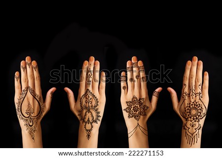 hand with mehendi on black background