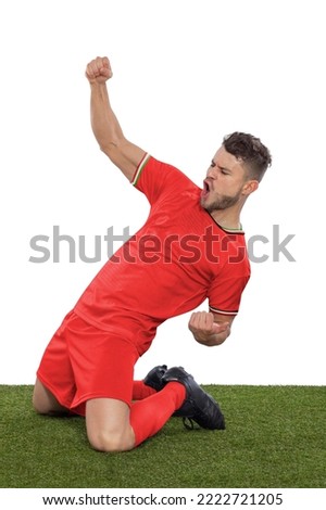 Professional soccer player with a red IR IRAN national team jersey shouting with excitement for scoring a goal with an expression of challenge and happiness on a white background. Royalty-Free Stock Photo #2222721205