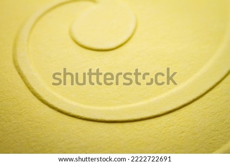 Extreme macro of embossed yellow paper. Selective focus, shallow depth of field.