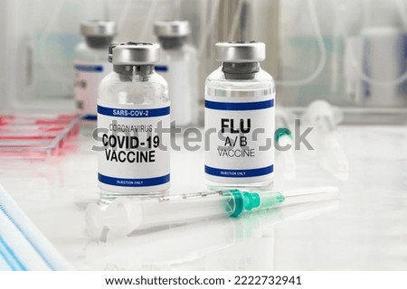 Coronavirus vaccine bottles and Flu Shot vaccine for booster vaccination for new variants of Sars-cov-2 virus and Influenza A. Flu A-B and Covid-19 vaccine booster shot for omicron and Influenza virus Royalty-Free Stock Photo #2222732941